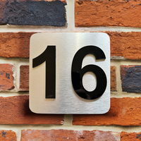 montage huisnummerbord rvs look met afstandhouders aan gevel